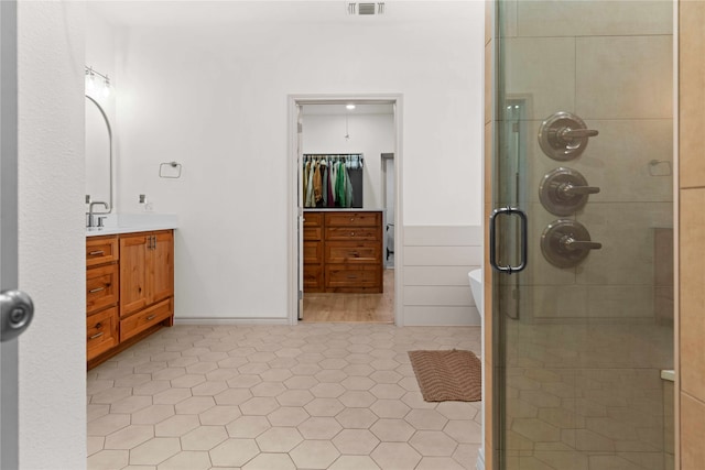 bathroom featuring vanity, tile patterned floors, and a shower with shower door