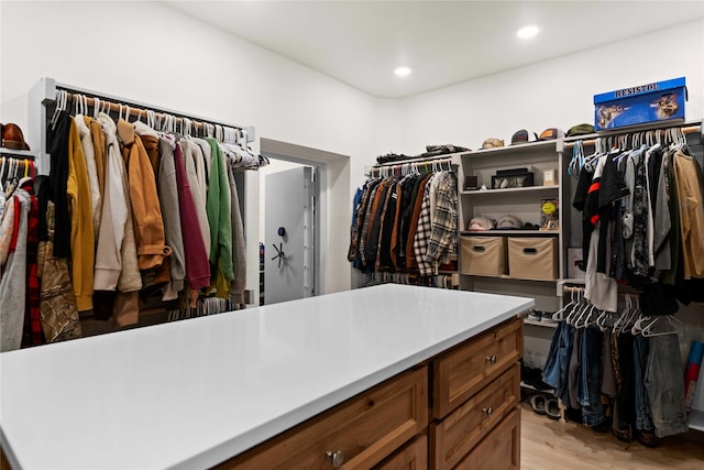 walk in closet with light hardwood / wood-style flooring