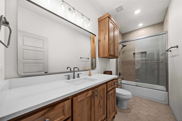 full bathroom with tile patterned flooring, shower / bath combination with glass door, vanity, and toilet