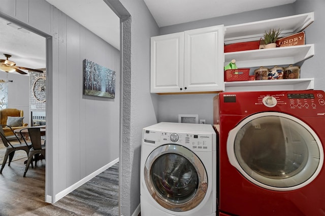 clothes washing area with hardwood / wood-style flooring, ceiling fan, separate washer and dryer, cabinets, and wood walls