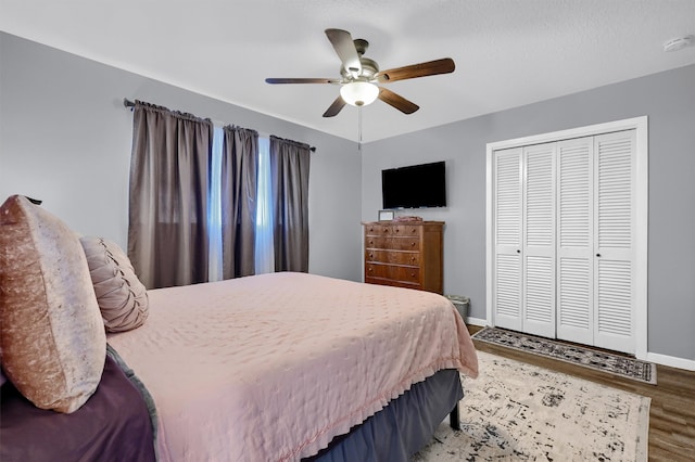 bedroom with hardwood / wood-style floors, a closet, and ceiling fan