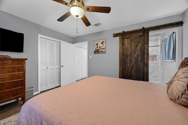 bedroom featuring a barn door and ceiling fan