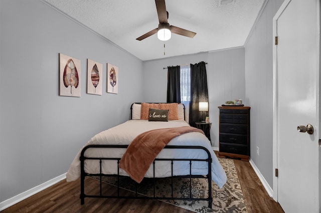 bedroom featuring crown molding, a textured ceiling, dark wood-type flooring, and ceiling fan