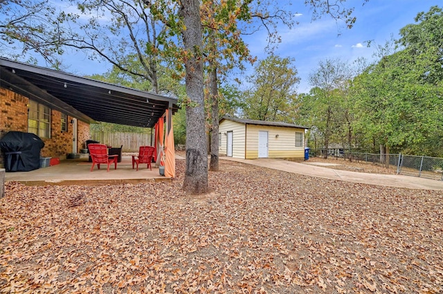 view of yard featuring an outdoor structure and a patio area