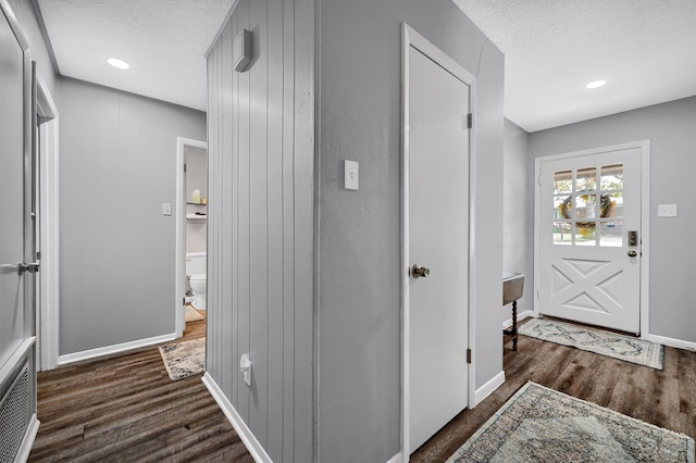 foyer with a textured ceiling and dark hardwood / wood-style floors