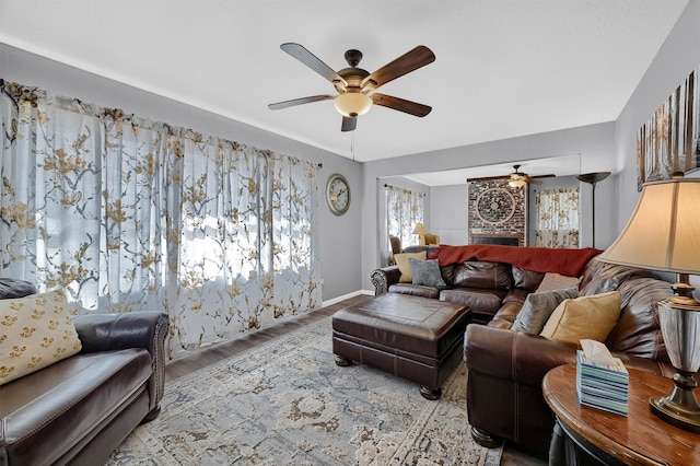 living room with light hardwood / wood-style flooring, a fireplace, and ceiling fan