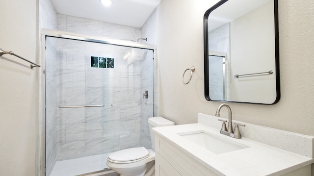 bathroom with an enclosed shower, vanity, and toilet