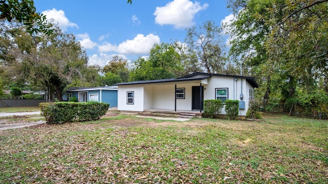 single story home with a front yard and covered porch