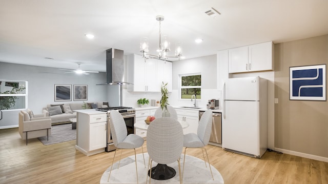 kitchen featuring white cabinetry, stainless steel appliances, wall chimney range hood, and light hardwood / wood-style flooring