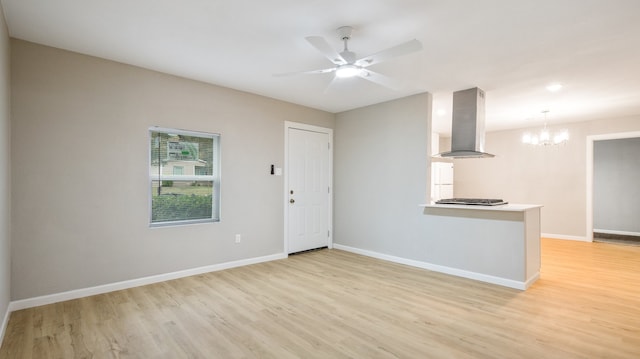 unfurnished room featuring ceiling fan with notable chandelier and light hardwood / wood-style flooring