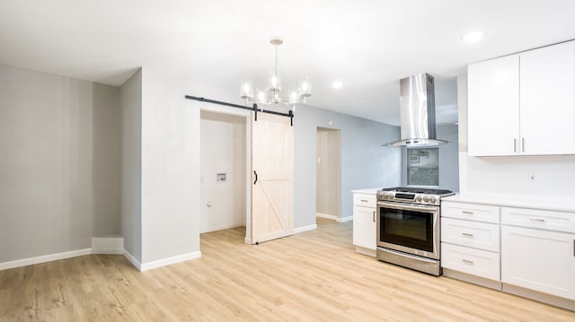 kitchen featuring a barn door, exhaust hood, white cabinets, stainless steel range oven, and light hardwood / wood-style flooring