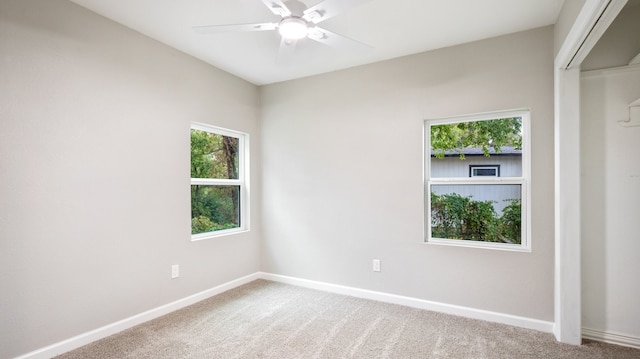 carpeted spare room featuring ceiling fan