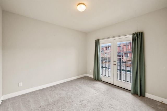 spare room featuring french doors and light colored carpet