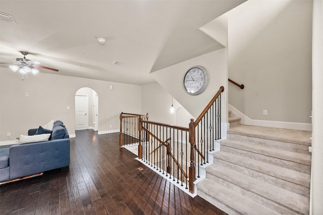 stairs with hardwood / wood-style floors and ceiling fan