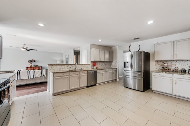 kitchen with sink, appliances with stainless steel finishes, kitchen peninsula, and tasteful backsplash