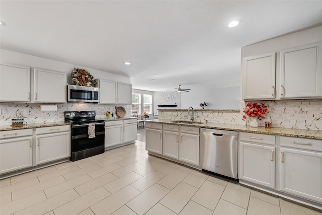 kitchen featuring sink, ceiling fan, stainless steel appliances, white cabinets, and decorative backsplash