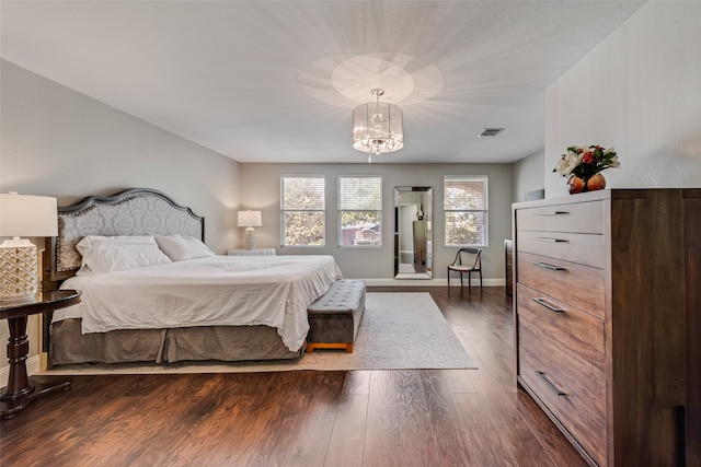 bedroom featuring dark wood-type flooring and a chandelier