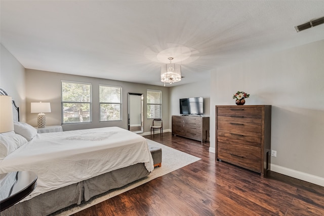 bedroom with dark hardwood / wood-style flooring and a chandelier