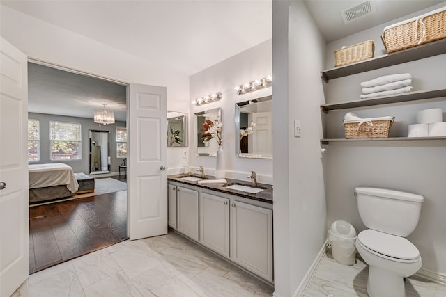 bathroom with vanity, a notable chandelier, wood-type flooring, and toilet