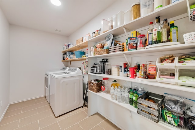 clothes washing area with light tile patterned floors and washing machine and clothes dryer