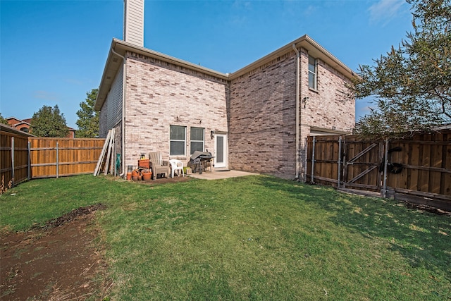 rear view of house with a patio and a lawn