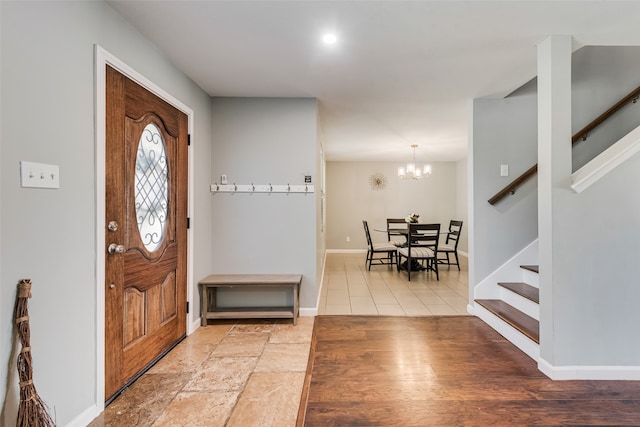 entryway with wood-type flooring and an inviting chandelier