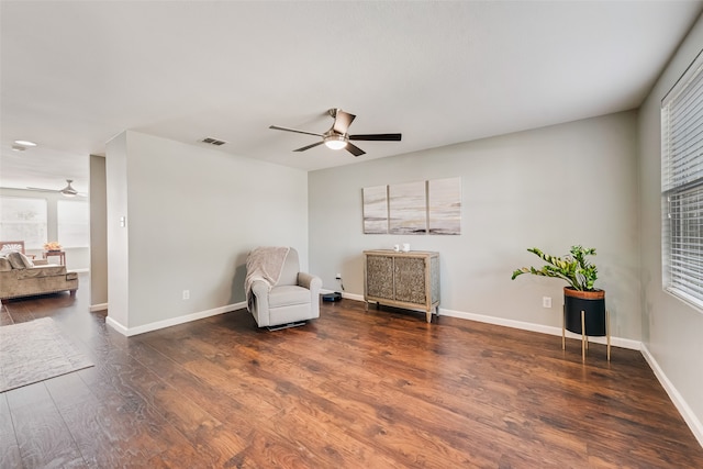 sitting room with dark wood-type flooring and ceiling fan