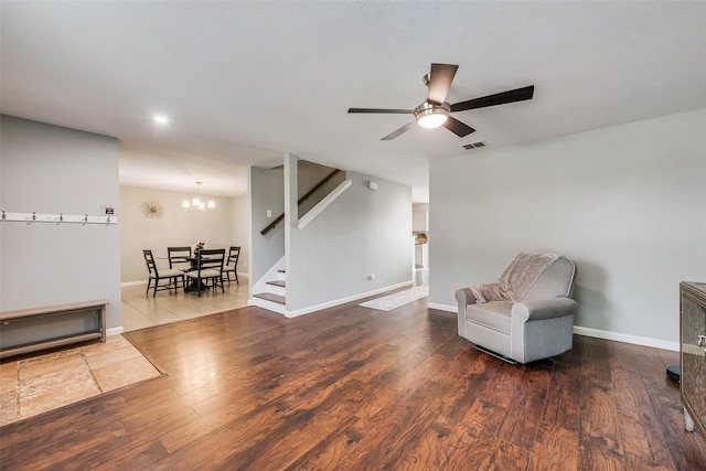 sitting room with wood-type flooring and ceiling fan with notable chandelier