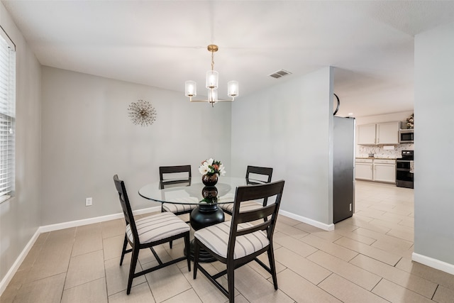 dining area featuring light tile patterned floors and a chandelier