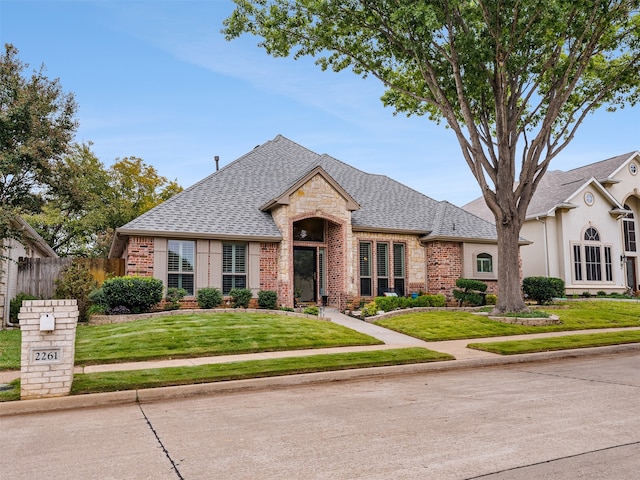 french country inspired facade featuring a front lawn