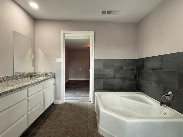 bathroom featuring vanity, a tub, and tile patterned flooring