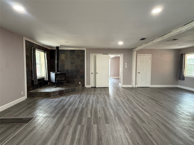 unfurnished living room featuring hardwood / wood-style flooring and a wood stove