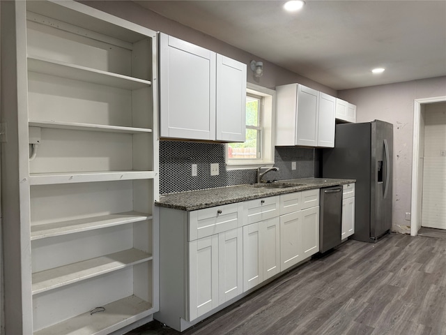 kitchen featuring appliances with stainless steel finishes, dark wood-type flooring, white cabinets, and dark stone counters