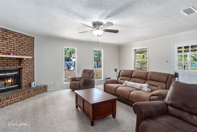 carpeted living room featuring a brick fireplace, a textured ceiling, and plenty of natural light