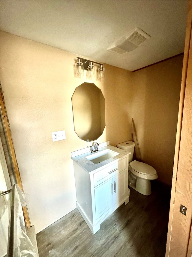 bathroom with vanity, hardwood / wood-style flooring, and toilet