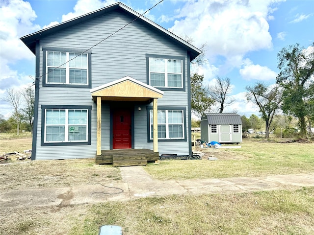 view of front of property featuring a shed and a front lawn