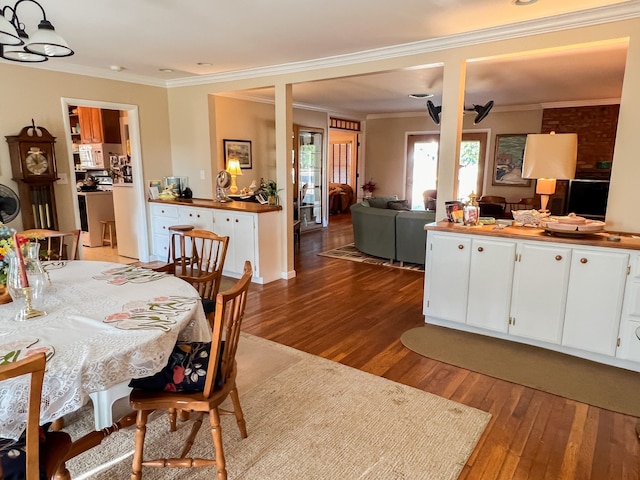 dining area featuring hardwood / wood-style floors, crown molding, and ceiling fan