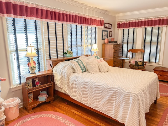 bedroom featuring ornamental molding, multiple windows, and wood-type flooring