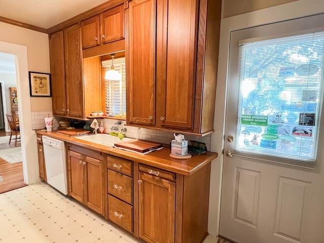 kitchen featuring decorative backsplash, hanging light fixtures, white dishwasher, ornamental molding, and sink