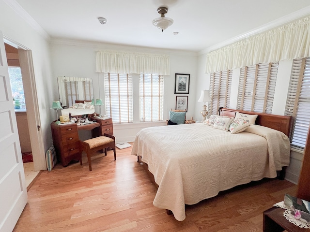 bedroom with light hardwood / wood-style floors and crown molding