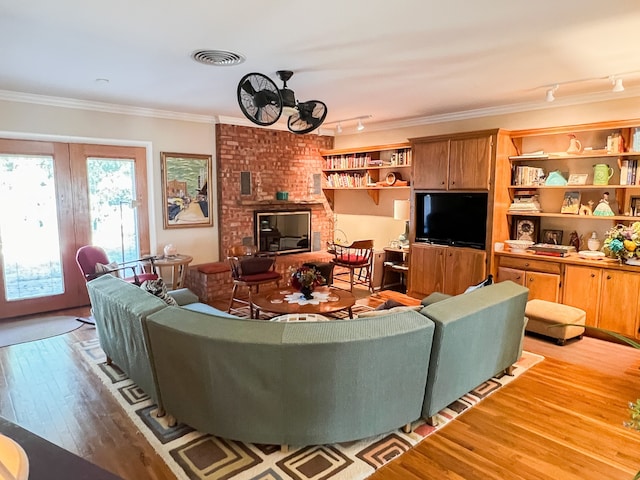 living room featuring ornamental molding, french doors, light hardwood / wood-style flooring, and rail lighting