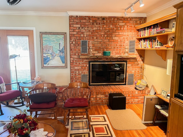 living room featuring hardwood / wood-style flooring, ornamental molding, and plenty of natural light