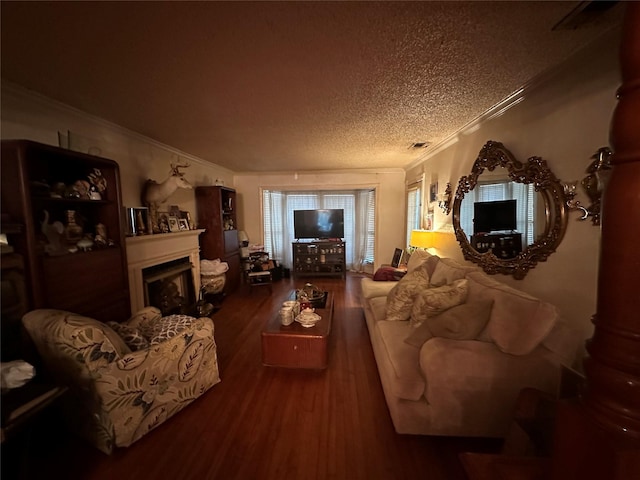 living room featuring a fireplace, wood finished floors, ornamental molding, and a textured ceiling