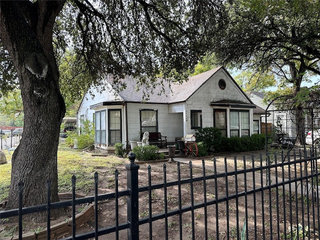 view of front facade with a fenced front yard and roof with shingles