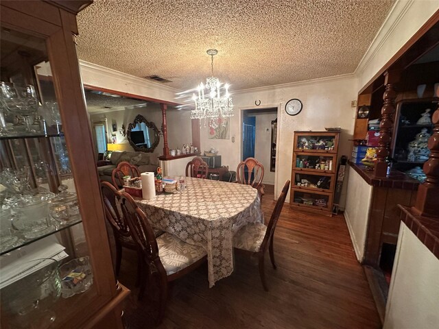 dining space with crown molding, a chandelier, wood finished floors, a textured ceiling, and visible vents