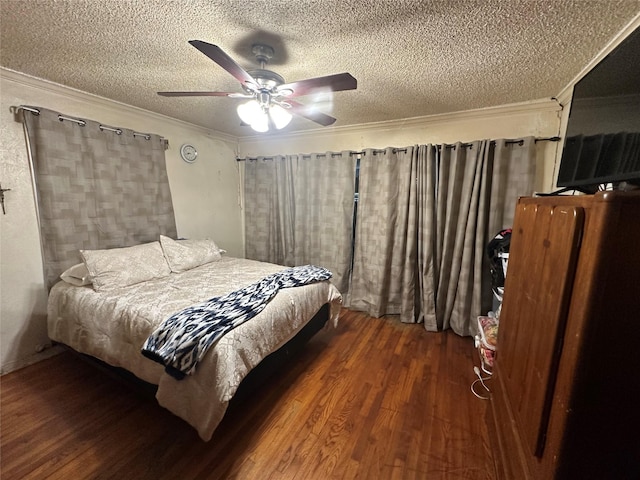 bedroom with ornamental molding, a textured ceiling, ceiling fan, and wood finished floors