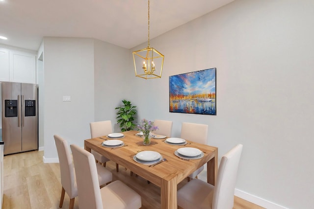 dining space featuring light hardwood / wood-style floors and an inviting chandelier