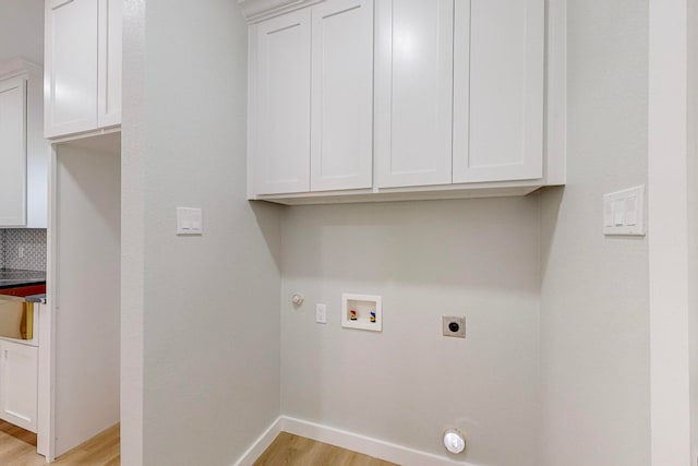 laundry room with hookup for a gas dryer, hookup for a washing machine, hookup for an electric dryer, cabinets, and light hardwood / wood-style floors