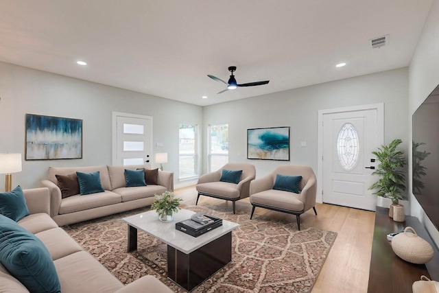 living room with ceiling fan and light hardwood / wood-style flooring