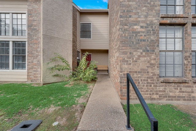 property entrance with a lawn